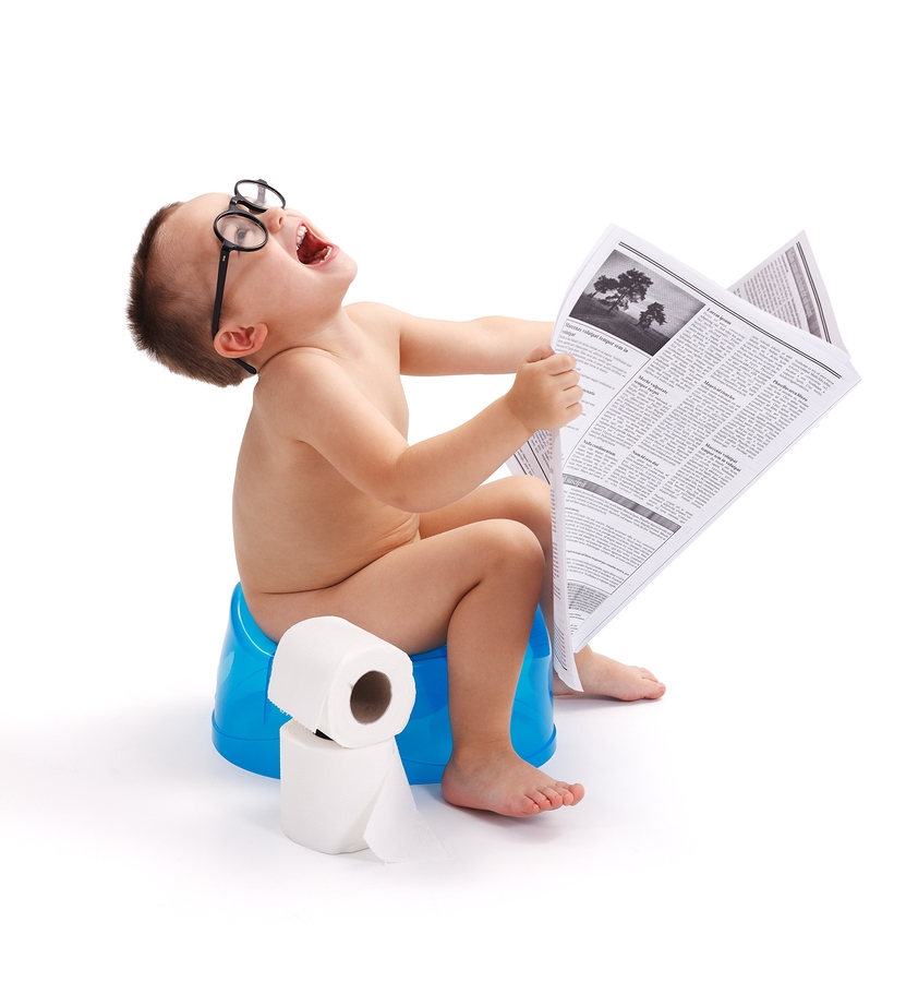 Little Boy Sitting On Potty With Newspaper