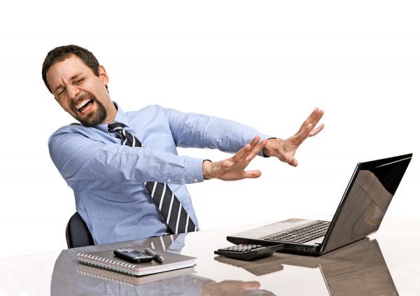 overwhelmed businessman close his eyes and turned away from the laptop screen - isolated on white background